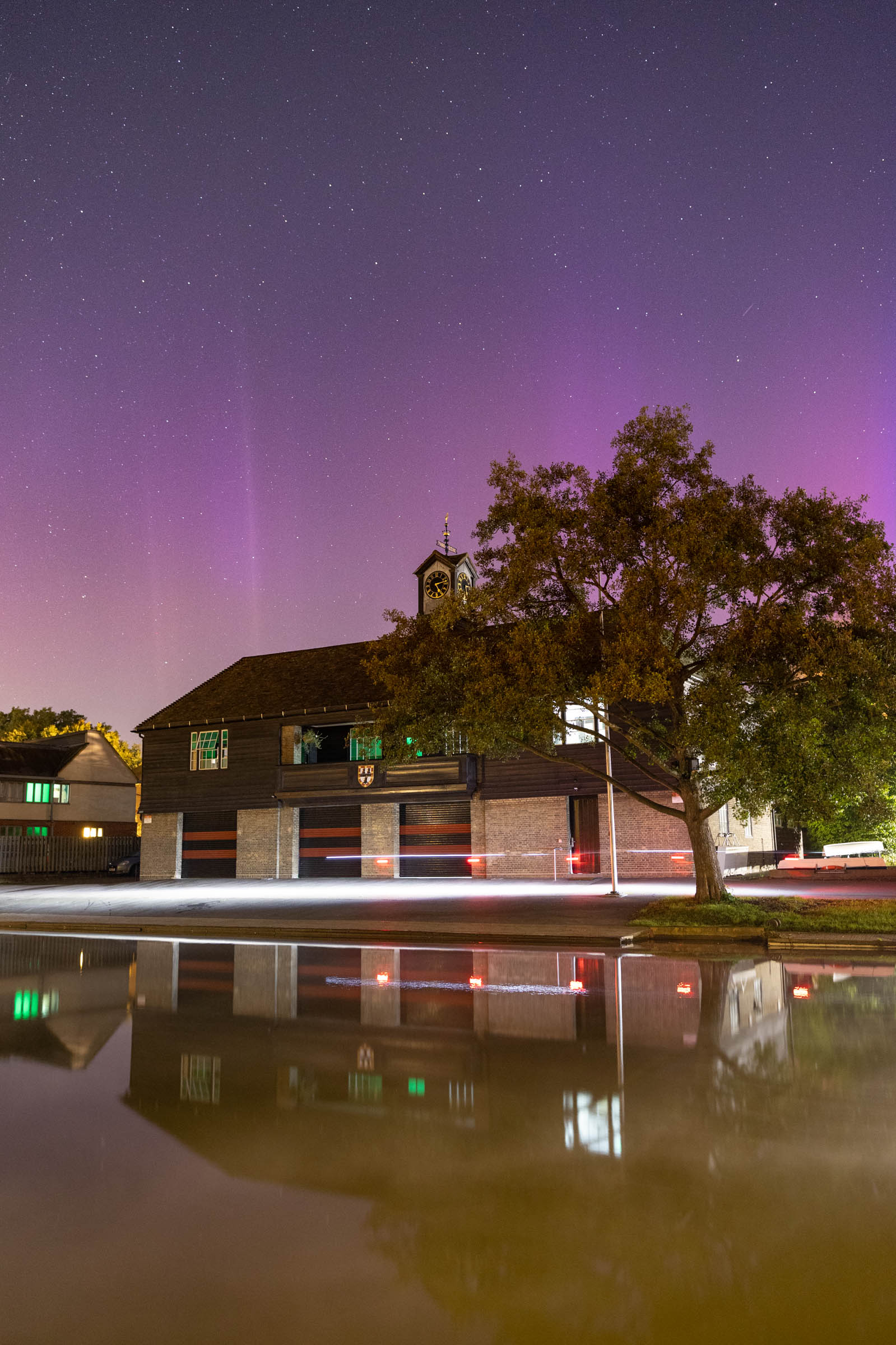 The aurora continues as rowers cycle past Jesus College Boathouse, October 2024